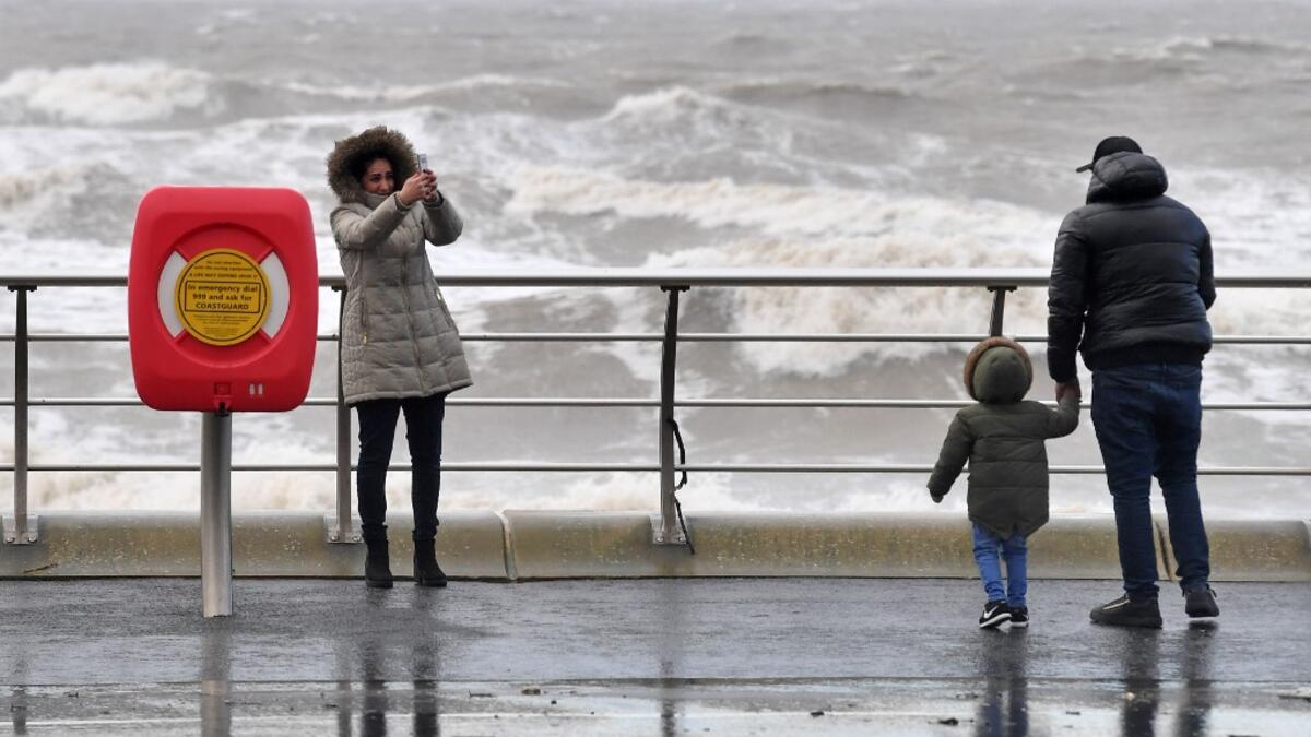 A woman takes a selfie photo with the stormy sea behind her in Blackpool, northwest England on February 9, 2020, as Storm Ciara swept over the country. Britain and Ireland hunkered down Sunday for a powerful storm expected to disrupt air, rail and sea links, cancel sports events, cut electrical power and damage property. With howling winds and driving rain, forecasters said Ciara would also hit France, Belgium, the Netherlands, Switzerland and Germany. Paul ELLIS / AFP