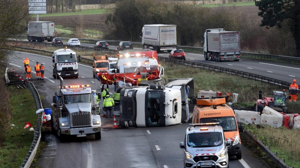 Rescuers work on the A2 motorway in Marly, northern France, after a truck was tipped over in the early morning from strong winds brought by storm Ciara on February 10, 2020. Hundreds of flights and train services were cancelled on February 10 as Storm Ciara sweeps over northwest Europe packing powerful winds, and leaving swatches of Europe without power after unleashing torrential rain and causing flash flooding. FRANCOIS LO PRESTI / AFP