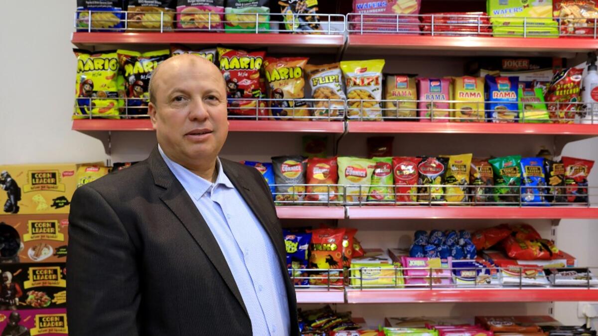 Wael al-Wadiya, chairman of Sarayo Alwadiya company, poses for a photo in front of some of the products his factory produces in Gaza City on February 4, 2020. Israel permits some vegetables and clothing to be sold abroad but not processed food.  EMMANUEL DUNAND / AFP