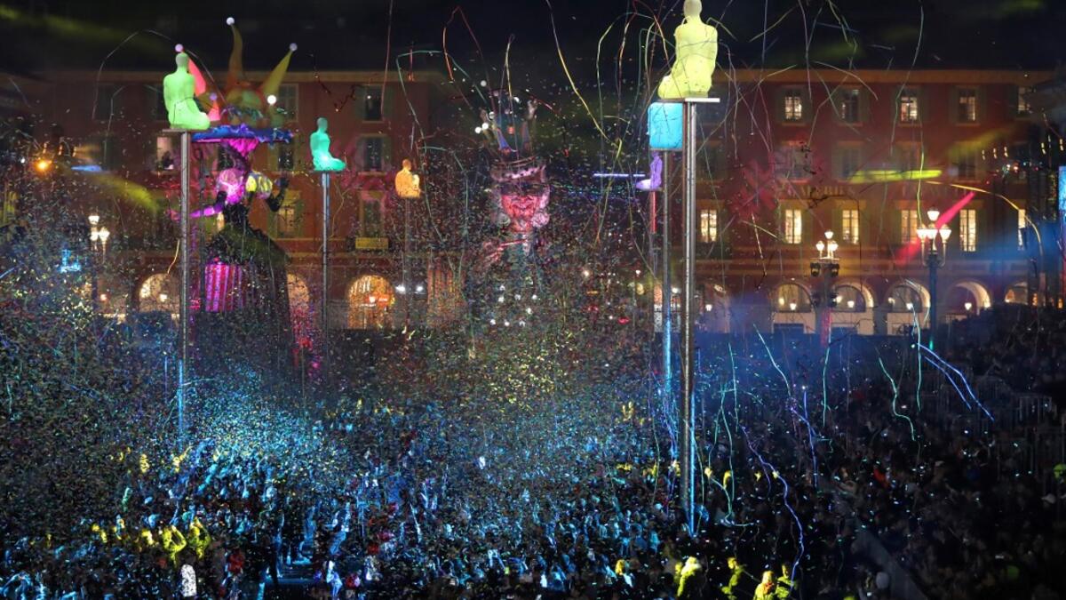 Giant figures depicting a king and a queen are seen through confetti rain during the 136th Nice Carnival parade in Nice, southeastern France, on February 15, 2020. The Carnival takes place until February 29, 2020 on the theme 'King of Fashion'. VALERY HACHE / AFP