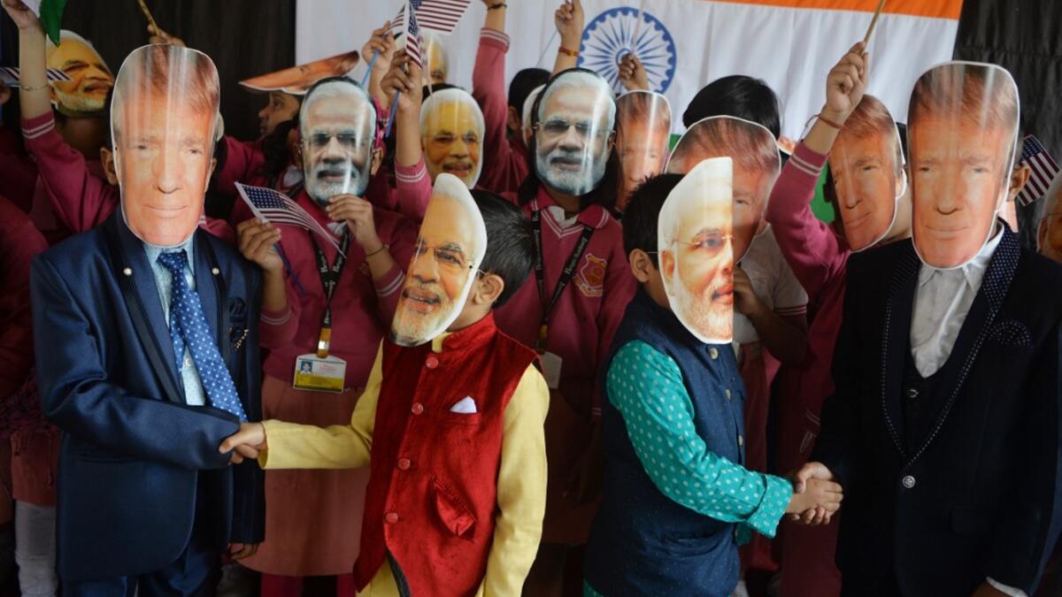 Indian school children wearing masks of Indian Prime Minister Narendra Modi and US President Donald Trump pose for a picture while shaking hands at Bright Academy school in Siliguri on February 24, 2020, on the occasion of Trump's first official visit to India. DIPTENDU DUTTA / AFP
