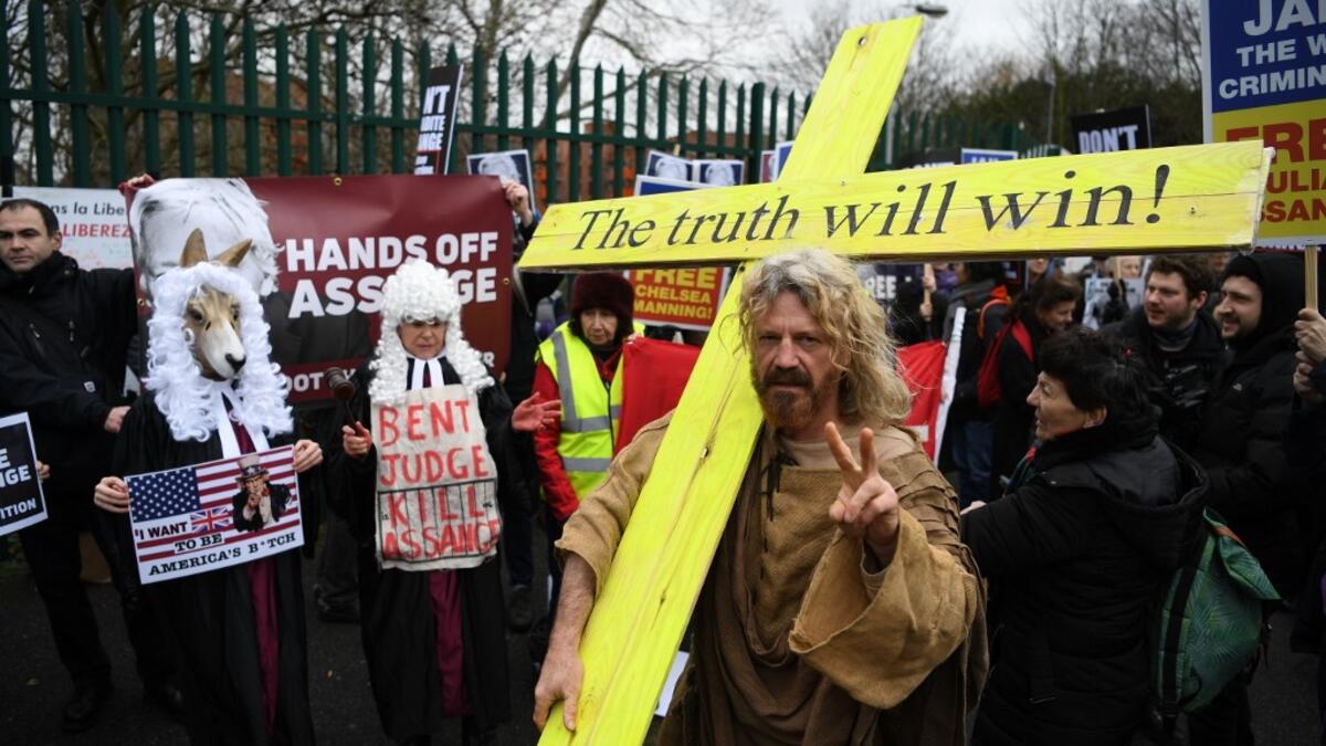 An activist supporting WikiLeaks founder Julian Assange dressed as Jesus with a cross joins other supporters in calling for his freedom outside Woolwich Crown Court in southeast London on February 24, 2020, on the day of the opening of the full hearing into a US request for Assange's extradition. A British court on February 24 starts hearing Washington's extradition request for WikiLeaks founder Julian Assange in a test case of media freedoms in the digital age and the global limits of US justice.  DANIEL L