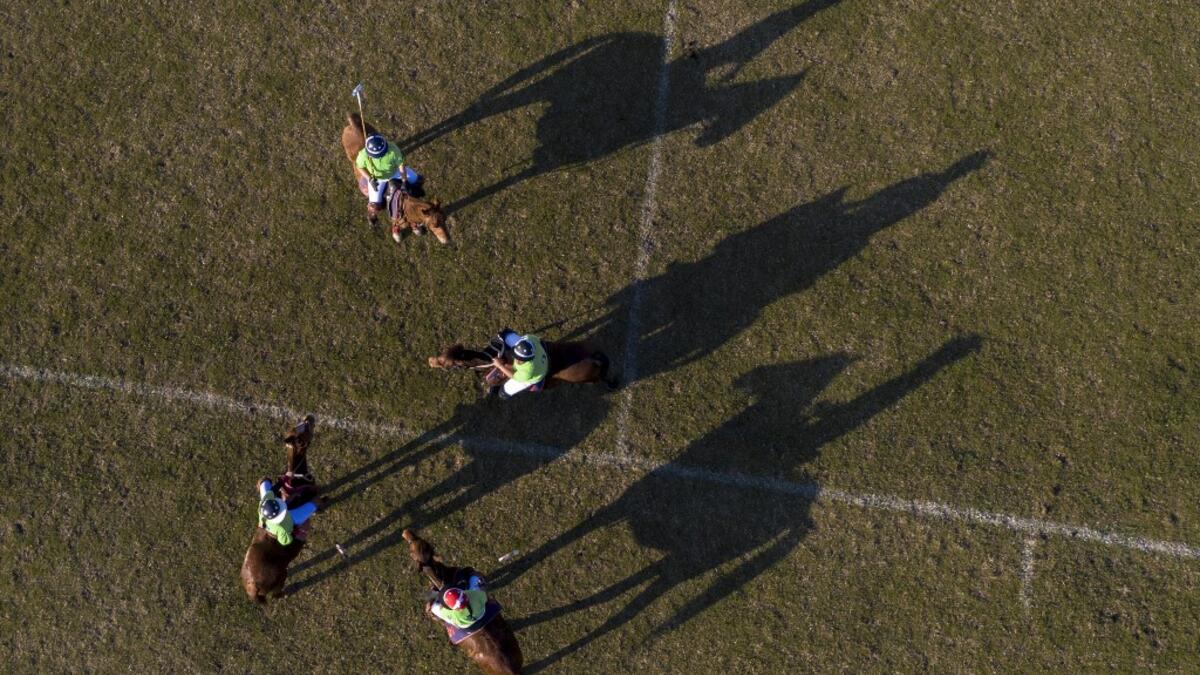 In this aerial photograph taken on January 11, 2020, Linthoingambi Kangjei Lup Polo Club players on their ponies gather on the field during a break of their 15th Women's State Polo Tournament match at the Mapal Kangjeibung (Polo Ground) in Imphal, the capital of the northeastern Indian state of Manipur. Laishram Thadoi's face is a picture of concentration as she adjusts her helmet and prepares to play in Manipur, the remote Indian state regarded as the birthplace of modern polo. Xavier GALIANA / AFP