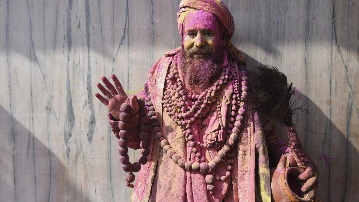 A sadhu (Hindu holy man) gestures to the camera during Holi celebrations, the spring festival of colours, in Nandgaon village in Uttar Pradesh state on March 5, 2020. Holi is observed in India at the end of the winter season on the last full moon of the lunar month. Money SHARMA / AFP