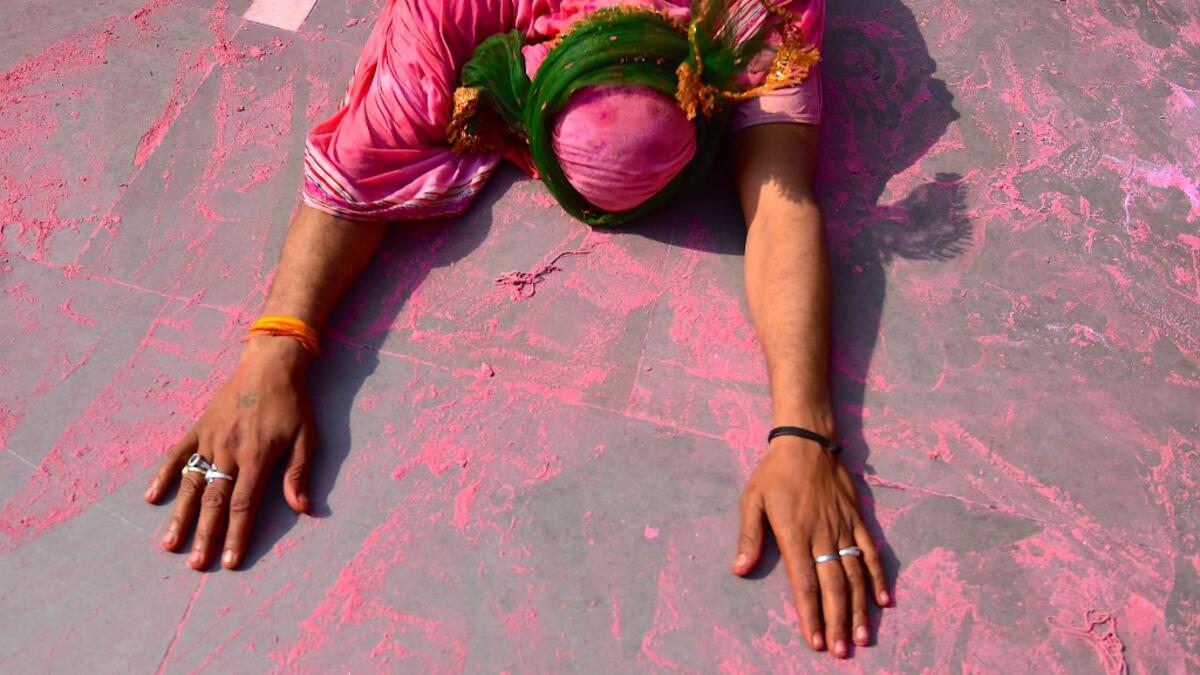 A Hindu devotee lies down as he enters the temple on the occasion of Holi, the spring festival of colours, during a traditional gathering at a temple in Nandgaon village in Uttar Pradesh state on March 5, 2020. Holi is observed in India at the end of the winter season on the last full moon of the lunar month. Money SHARMA / AFP
