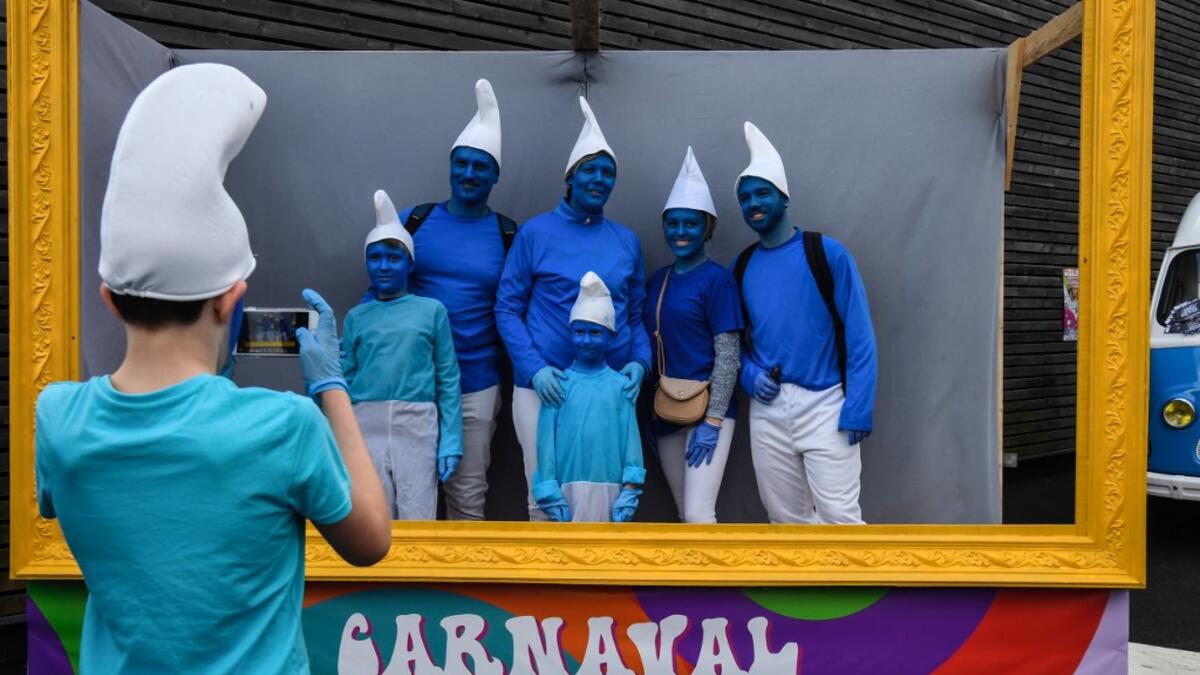 People dressed as Smurfs ('Schtroumpfs' in French), a Belgian comic franchise centered on a fictional colony of small, blue, human-like creatures who live in mushroom-shaped houses in the forest, pose for a picture during a world record gathering of Smurfs on March 7, 2020, in Landerneau, western France. Damien MEYER / AFP
