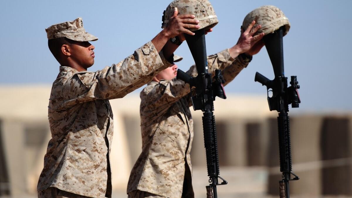 In this file photo taken on January 30, 2010, US Marines from 1st Battalion, 6th regiment, Charlie company prepare memorials for Sergeant Daniel Angus and Lance Corporal Zachary Smith, who were killed on the battlefield on January 24, in Fiddler's Green camp, on the outskirts of Marjah in central Helmand. American forces have started pulling out of two bases in Afghanistan, a US official said on March 10, 2020 the day peace talks between Kabul and the Taliban were due to start despite widespread violence an