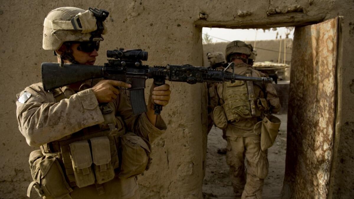 In this file photo taken on July 12, 2009, US Marines of 1st Combat Engineering Battalion of 2nd Marine Expeditionary Brigade search a compound in the Garmsir district of Helmand Province. American forces have started pulling out of two bases in Afghanistan, a US official said on March 10, 2020 the day peace talks between Kabul and the Taliban were due to start despite widespread violence and a political crisis. The United States is keen to end its longest-ever conflict, and under the terms of a deal signed