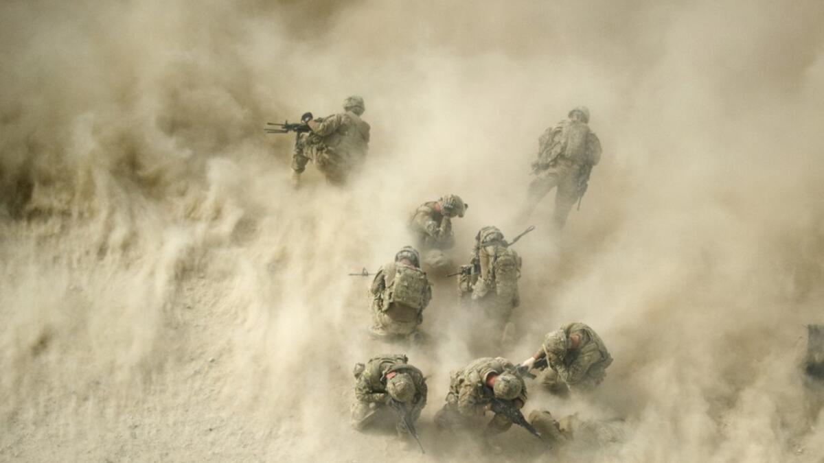 In this file photo taken on August 23, 2011, US soldiers gather near a destroyed vehicle and protect their faces from rotor wash, as their wounded comrades are airlifted by a Medevac helicopter from the 159th Brigade Task Force Thunder to Kandahar Hospital Role 3. American forces have started pulling out of two bases in Afghanistan, a US official said on March 10, 2020 the day peace talks between Kabul and the Taliban were due to start despite widespread violence and a political crisis. The United States is