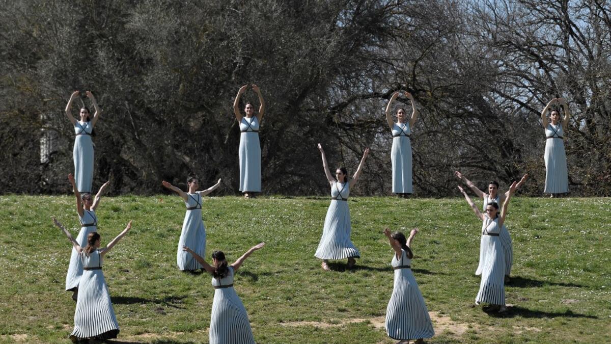 Women dressed as a priestesses take part in the Olympic flame lighting ceremony in ancient Olympia, ahead of Tokyo 2020 Olympic Games on March 12, 2020. LOUISA GOULIAMAKI / AFP