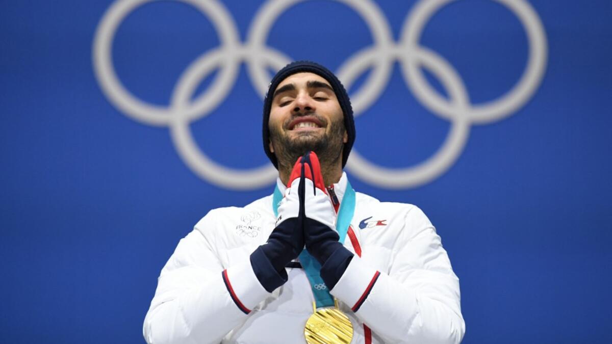 In this file photo taken on February 19, 2018 France's gold medallist Martin Fourcade reacts on the podium during the medal ceremony for the biathlon men's 15km Mass Start at the Pyeongchang Medals Plaza during the Pyeongchang 2018 Winter Olympic Games in Pyeongchang. Five-time Olympic biathlon champion Martin Fourcade announced in a statement on March 13, 2020 that he would end his career at the end of the season, after the last race which will take place on March 14 in Kontiolahti, Finland. Kirill KUDRYAV