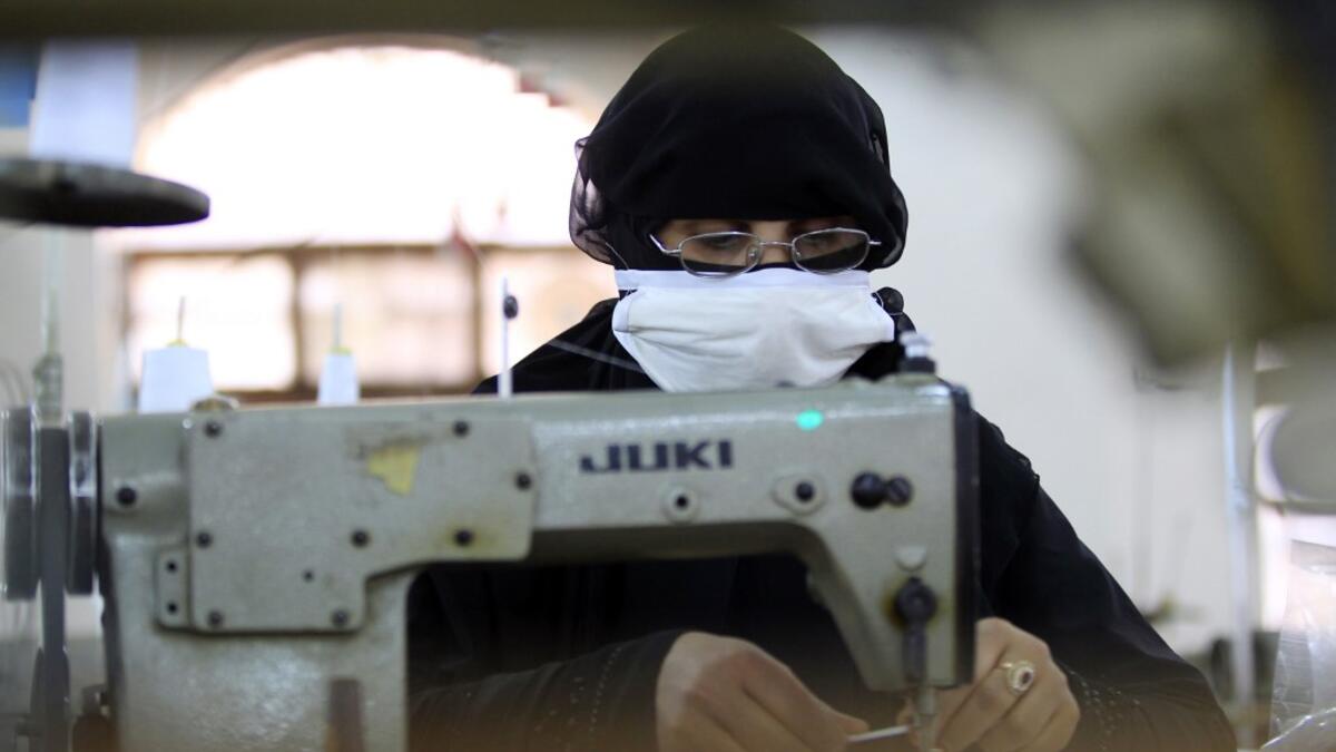 A Yemeni woman makes face masks at a textile factory in the capital Sanaa on March 16, 2020. More than a decade after it shut down, 20 women have brought back to life Yemen's oldest industrial factory to manufacture what could save many lives amid a global pandemic: masks. Mohammed HUWAIS / AFP
