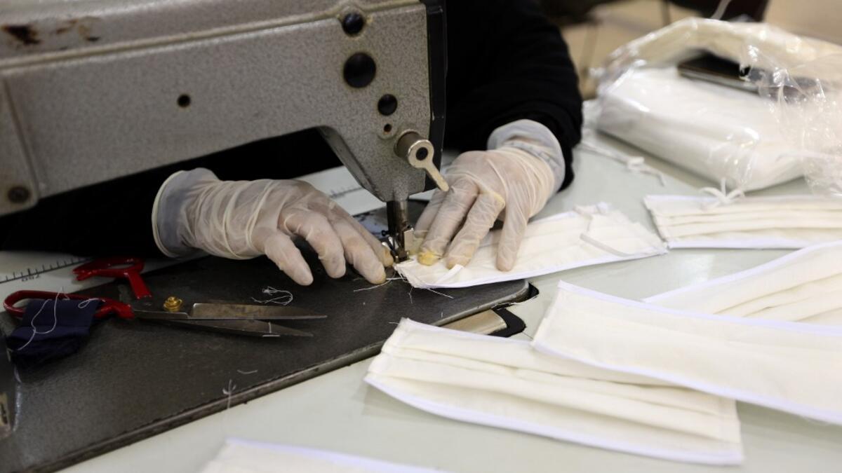 A Yemeni woman makes face masks at a textile factory in the capital Sanaa on March 16, 2020. More than a decade after it shut down, 20 women have brought back to life Yemen's oldest industrial factory to manufacture what could save many lives amid a global pandemic: masks. Mohammed HUWAIS / AFP