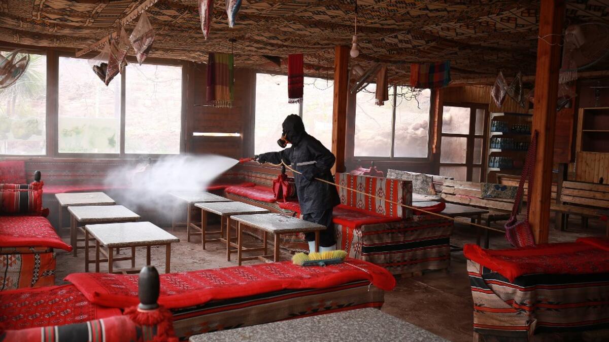 A labourer sprays disinfectant in Jordan's archaeological city of Petra south of the capital Amman on March 17, 2020, to prevent the spread of COVID-19. Khalil MAZRAAWI / afp