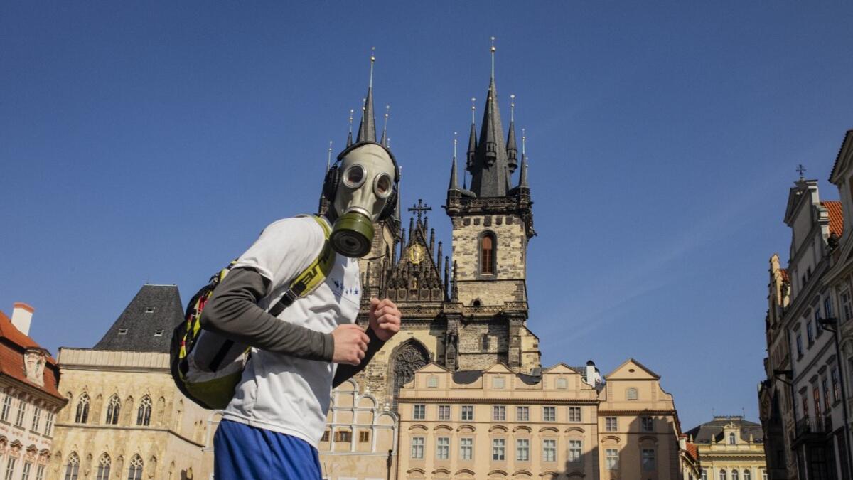 A man with a gas mask runs across the Old Town Square on March 18, 2020, in Prague, where activities came to a halt due to the spread of the novel coronavirus. The Czech Republic, a European Union country of 10.7 million people, has registered 464 confirmed cases of the virus, including three cured patients, and no deaths. Michal Cizek / AFP