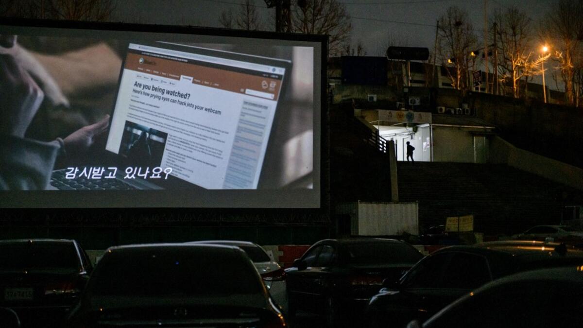 In a photo taken on March 21, 2020 a screen shows a movie at a drive-through cinema in Seoul. Box office numbers in South Korea -- which has 8,897 confirmed virus cases -- have plummeted in recent weeks due to the epidemic, with authorities urging the public to avoid large crowds. But at drive-in cinemas, moviegoers can enjoy a movie from the comfort of their cars, parked in front of a large outdoor screen.  Ed JONES / AFP