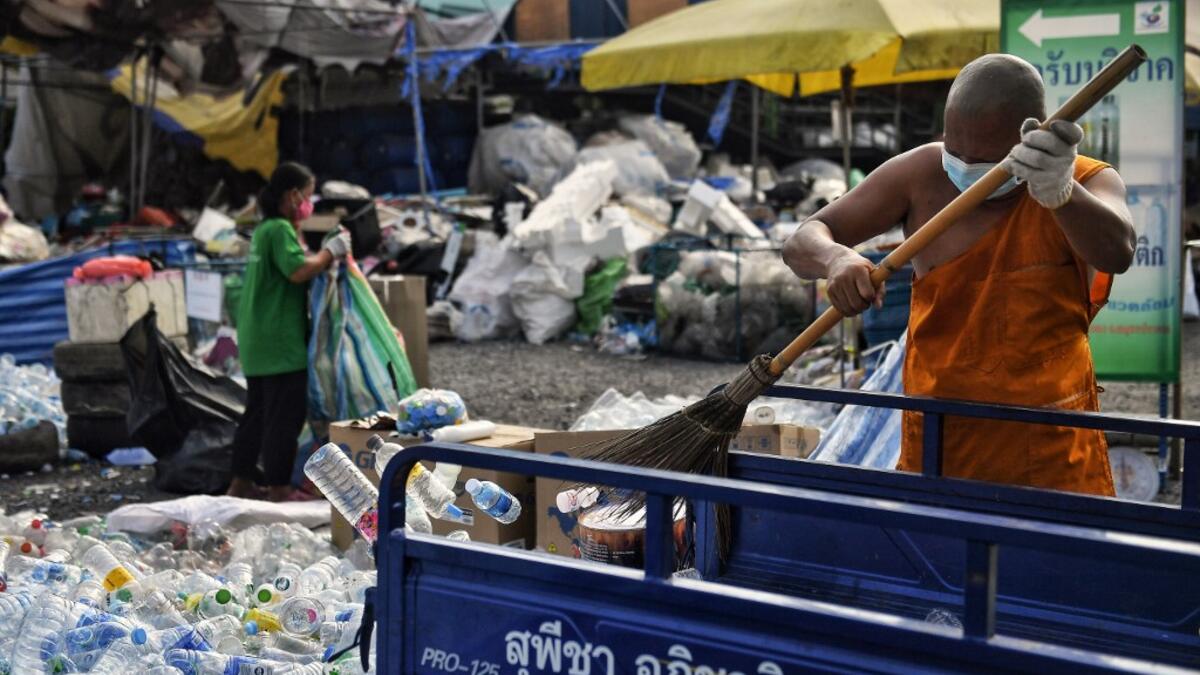 A Buddhist monk sorts salvaged plastic bottles to be recycled into monks’ robes and face masks, amid concerns over the spread of the COVID-19 coronavirus, at Wat Chak Daeng Buddhist temple in Samut Prakan on March 23, 2020. The plastic wastes are sent to a separate recycling facility processing it into thread materials and woven as special fabric for monks. Lillian SUWANRUMPHA / AFP