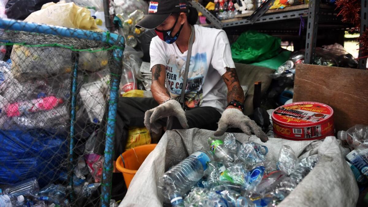 A Buddhist devotee sorts salvaged plastic bottles to be recycled into monks’ robes and face masks, amid concerns over the spread of the COVID-19 coronavirus, at Wat Chak Daeng Buddhist temple in Samut Prakan on March 23, 2020. The plastic wastes are sent to a separate recycling facility processing it into thread materials and woven as special fabric for monks. Lillian SUWANRUMPHA / AFP