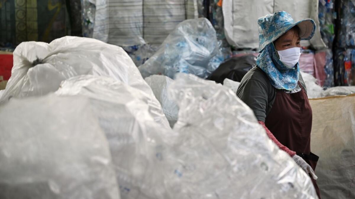 A Buddhist devotee sorts salvaged plastic bottles to be recycled into monks’ robes and face masks, amid concerns over the spread of the COVID-19 coronavirus, at Wat Chak Daeng Buddhist temple in Samut Prakan on March 23, 2020. The plastic wastes are sent to a separate recycling facility processing it into thread materials and woven as special fabric for monks. Lillian SUWANRUMPHA / AFP