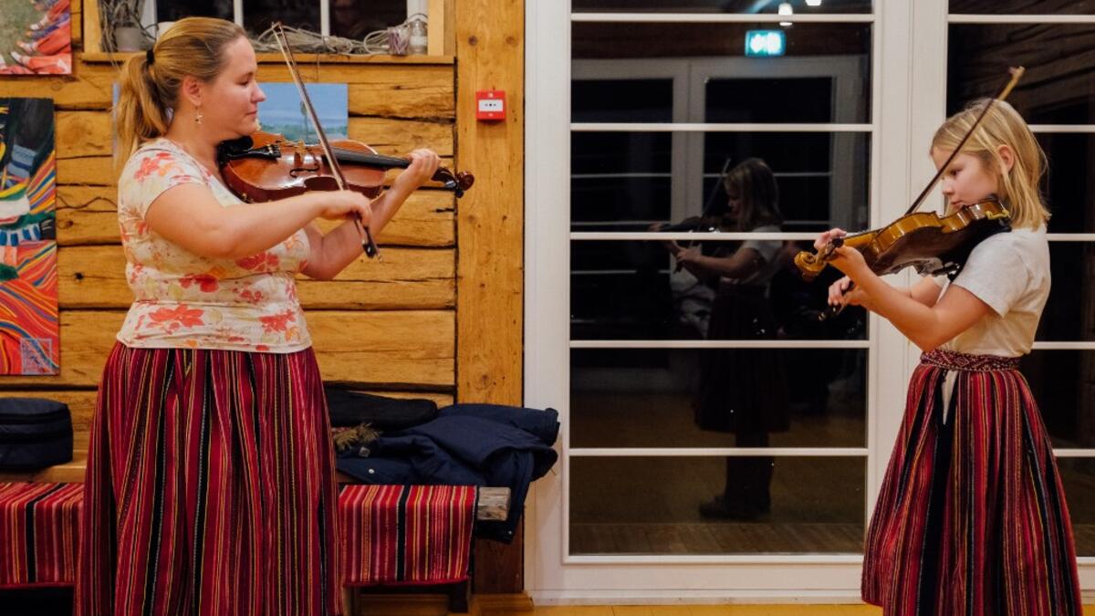 Maria Michelson, music teacher, gives a violon lesson on November 20, 2019 on Kihnu island in the Baltic Sea, 10 kilometres (six miles) off the coast of Estonia. Steeped in folk traditions, Kihnu's historic way of life however is now threatened as economic hardship drives more and more islanders away in search of work. Alessandro RAMPAZZO / AFP