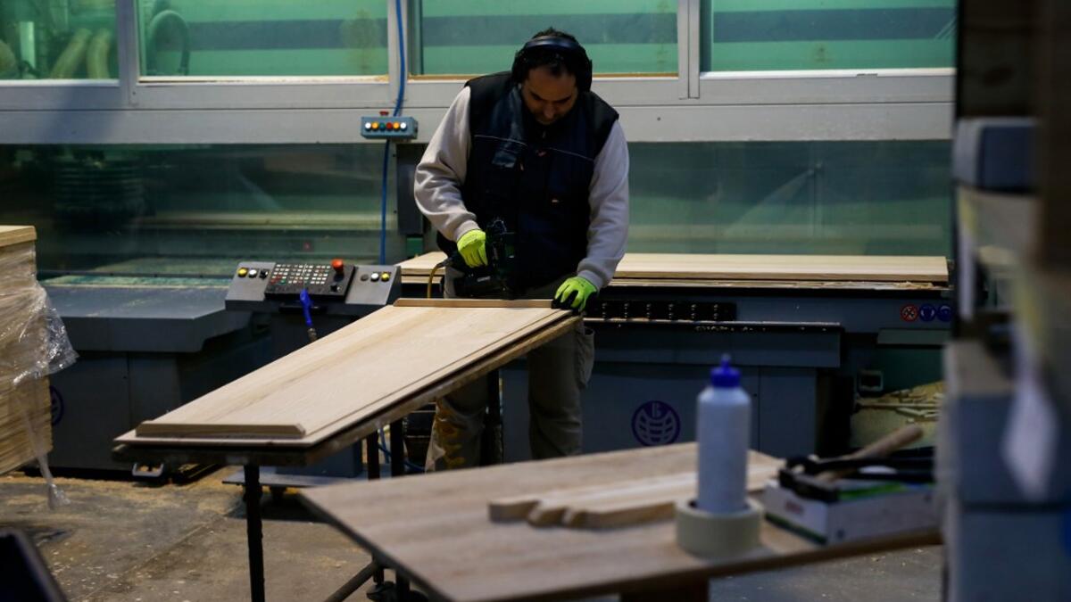An employee works at the Eurocoffin coffins factory in Barcelona on April 3, 2020. More than 900 people died in Spain over the past 24 hours for the second day running, government figures showed, although the rate of new infections and deaths continued to slow. Spain has the world's second-highest death toll after Italy with the virus so far claiming 10,935 lives from 117,710 confirmed cases.  PAU BARRENA / AFP