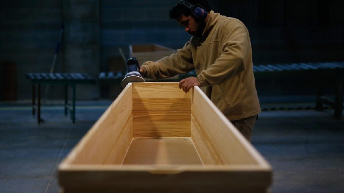 An employee polishes a coffin at the Eurocoffin coffins factory in Barcelona on April 3, 2020. More than 900 people died in Spain over the past 24 hours for the second day running, government figures showed, although the rate of new infections and deaths continued to slow. Spain has the world's second-highest death toll after Italy with the virus so far claiming 10,935 lives from 117,710 confirmed cases.  PAU BARRENA / AFP