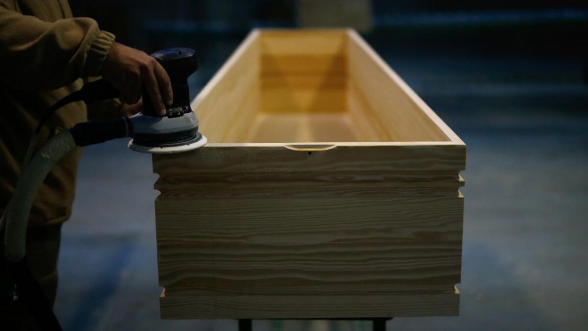 An employee polishes a coffin at the Eurocoffin coffins factory in Barcelona on April 3, 2020. More than 900 people died in Spain over the past 24 hours for the second day running, government figures showed, although the rate of new infections and deaths continued to slow. Spain has the world's second-highest death toll after Italy with the virus so far claiming 10,935 lives from 117,710 confirmed cases.  PAU BARRENA / AFP