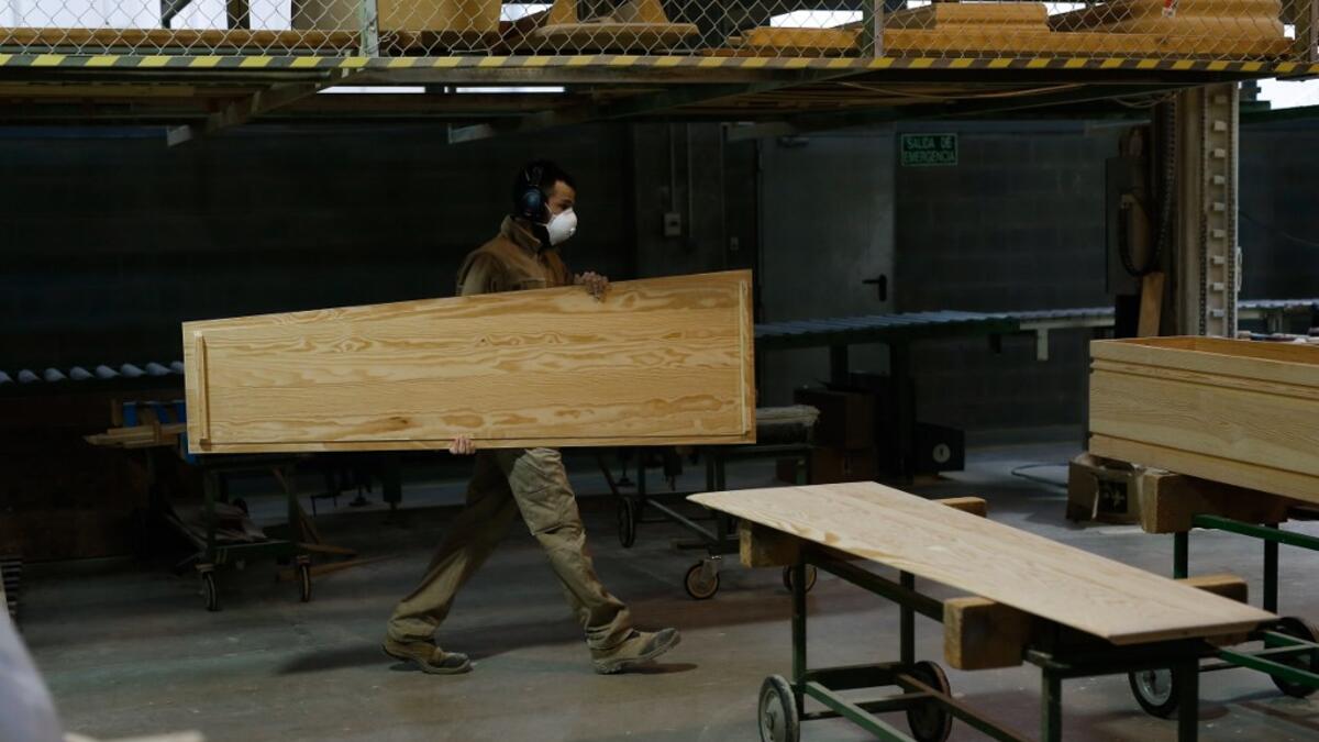 An employee works at the Eurocoffin coffins factory in Barcelona on April 3, 2020. More than 900 people died in Spain over the past 24 hours for the second day running, government figures showed, although the rate of new infections and deaths continued to slow. Spain has the world's second-highest death toll after Italy with the virus so far claiming 10,935 lives from 117,710 confirmed cases.  PAU BARRENA / AFP