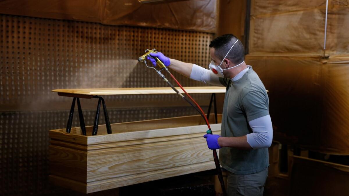 An employee makes a coffin at the Eurocoffin coffins factory in Barcelona on April 3, 2020. More than 900 people died in Spain over the past 24 hours for the second day running, government figures showed, although the rate of new infections and deaths continued to slow. Spain has the world's second-highest death toll after Italy with the virus so far claiming 10,935 lives from 117,710 confirmed cases.  PAU BARRENA / AFP