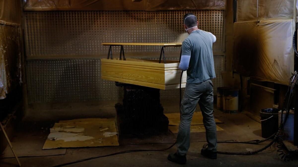 An employee makes a coffin at the Eurocoffin coffins factory in Barcelona on April 3, 2020. More than 900 people died in Spain over the past 24 hours for the second day running, government figures showed, although the rate of new infections and deaths continued to slow. Spain has the world's second-highest death toll after Italy with the virus so far claiming 10,935 lives from 117,710 confirmed cases.  PAU BARRENA / AFP