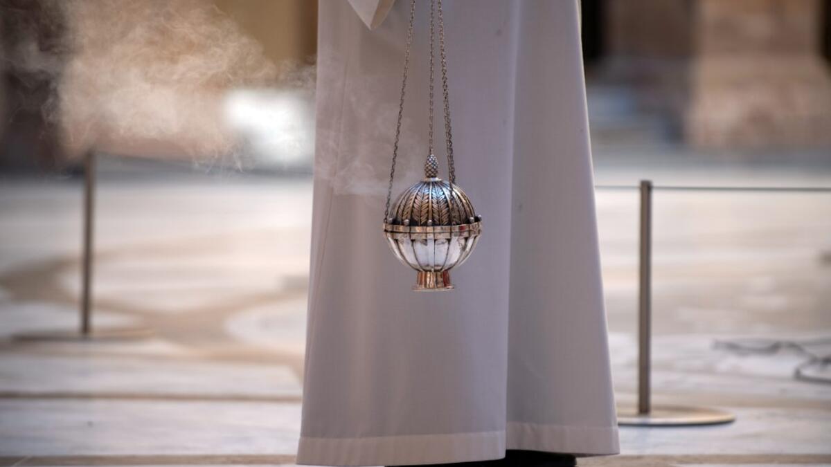 A priest holds an incense burner during the Palm Sunday Mass on April 5, 2020, at the Santa Maria de Montserrat abbey in Monistrol de Montserrat, during a national lockdown to prevent the spread of the COVID-19 disease. Spain saw its third consecutive daily decline in the number of people dying from the coronavirus pandemic as the country recorded another 674 fatalities today. Josep LAGO / AFP