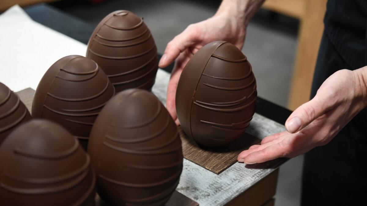 French chocolate maker Jeremy Thierry, adjusts a display chocolate Easter eggs in the workshop 'Atelier N° 5' in La Foret-Fouesnant, western France on April 7, 2020, ahead of the Christian Festival of Easter. Fred TANNEAU / AFP