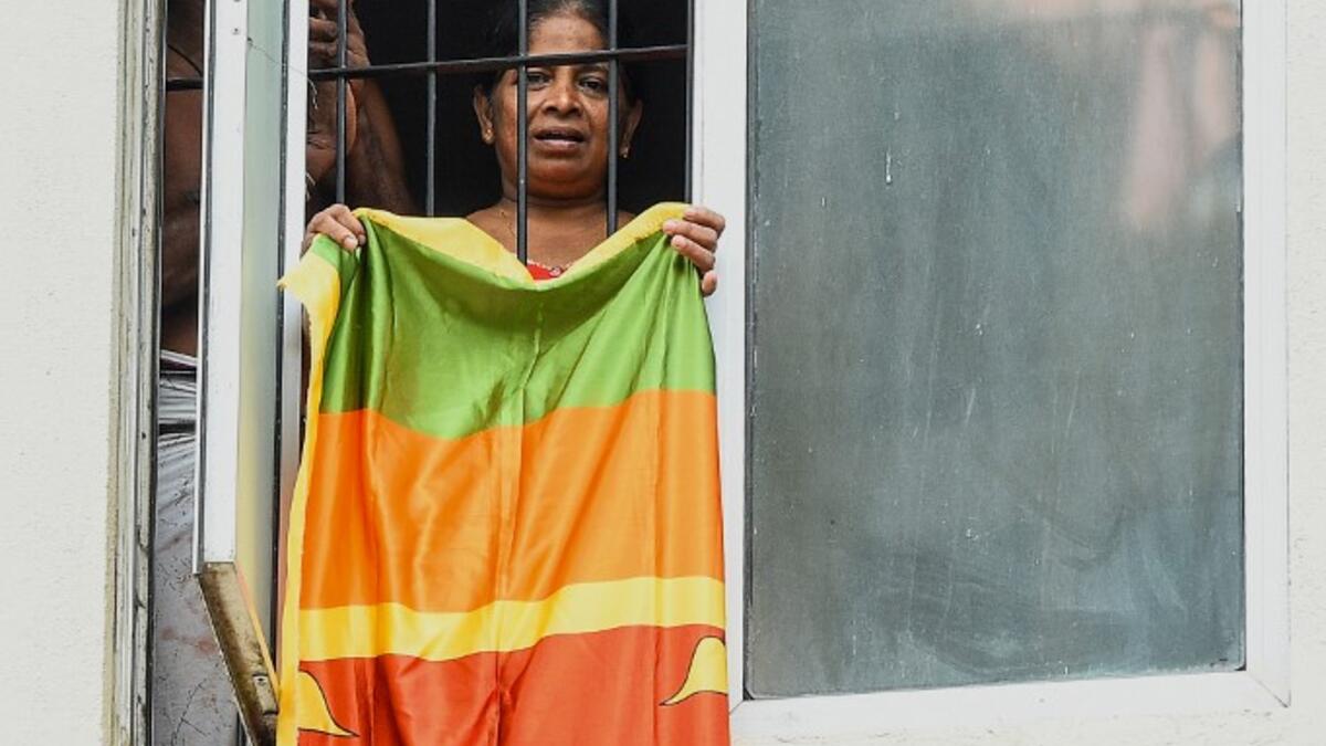 Residents watch from their flat's window a music band formed by Sri Lankan Navy personnel as they play outside a housing complex during a government-imposed nationwide lockdown as a preventive measure against the COVID-19 coronavirus, in Colombo on April 9, 2020. ISHARA S. KODIKARA / AFP