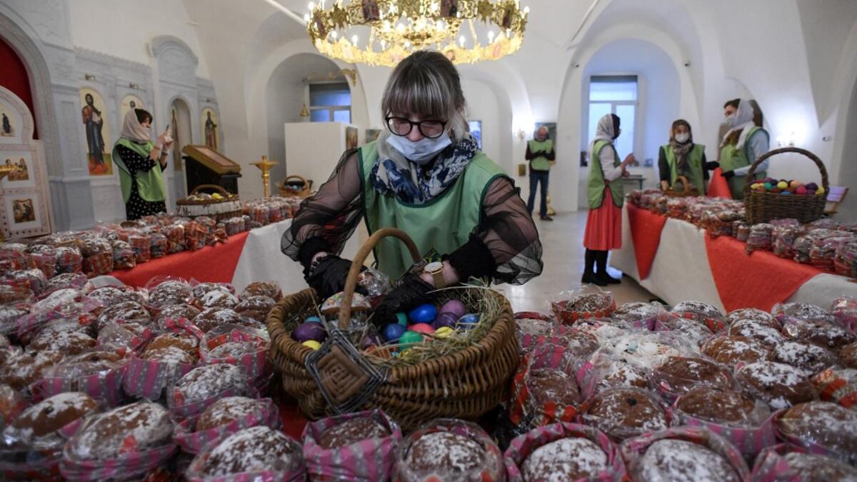 An Orthodox volunteer inspects traditional cakes and eggs before of blessing to be distributed to people in need, on the eve of the Orthodox Easter in Moscow on April 18, 2020, during a strict lockdown in Russia to stop the spread of COVID-19, caused by the novel coronavirus. All church in Moscow were closed to believers and remained open only for priests and personal. Kirill KUDRYAVTSEV / AFP