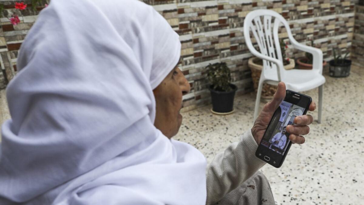 A Palestinian woman watches on her phone a sermon recorded and broadcast by a preacher from an empty mosque, due to the COVID-19 coronavirus pandemic, in the village of Salem east of Nablus in the occupied West Bank on the first Friday of the Muslim holy month of Ramadan on April 24, 2020. JAAFAR ASHTIYEH / AFP