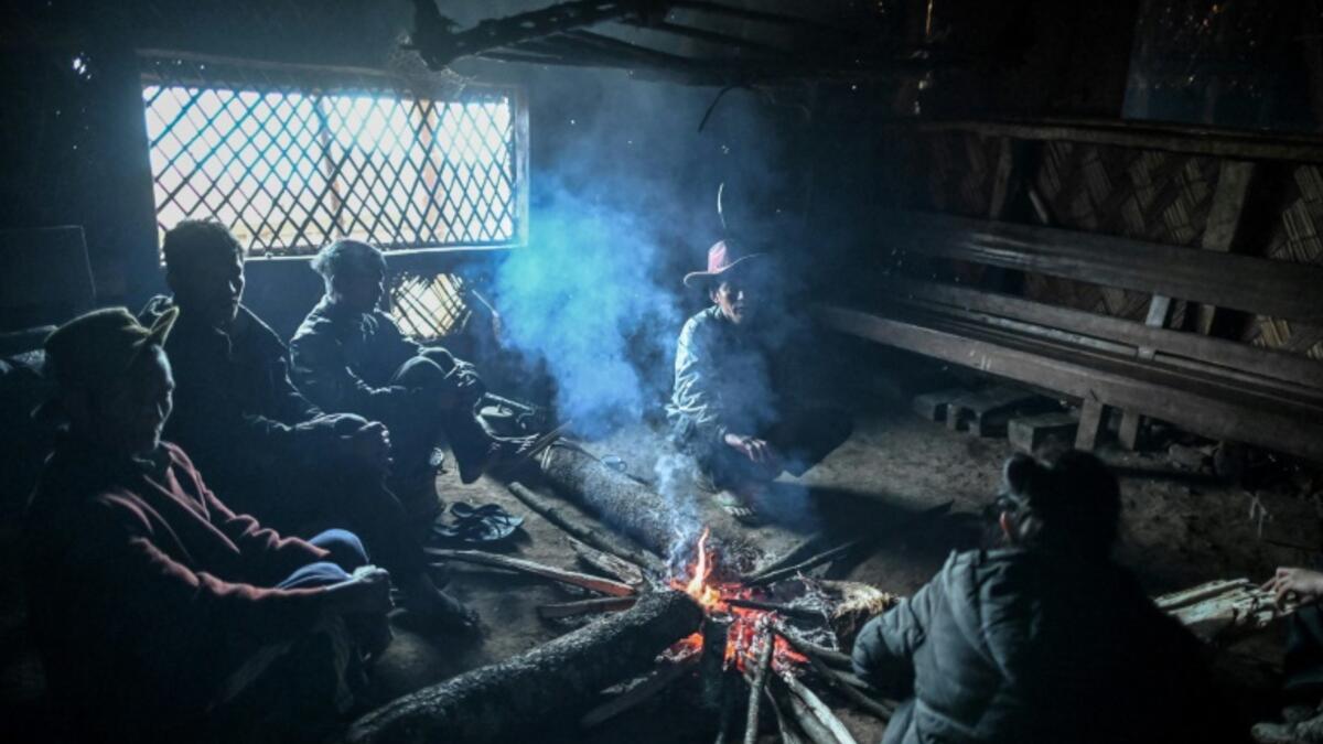 This photo taken on February 9, 2020 shows people resting inside their house in Karmawlawyi village in Myanmar's Sagaing region, near the border with India. The king of the Konyak tribe sleeps in Myanmar, but eats in India -- his house, village and people divided by a mountain border which serves as a vulnerable lifeline now severed by a coronavirus lockdown.  Ye Aung THU / AFP