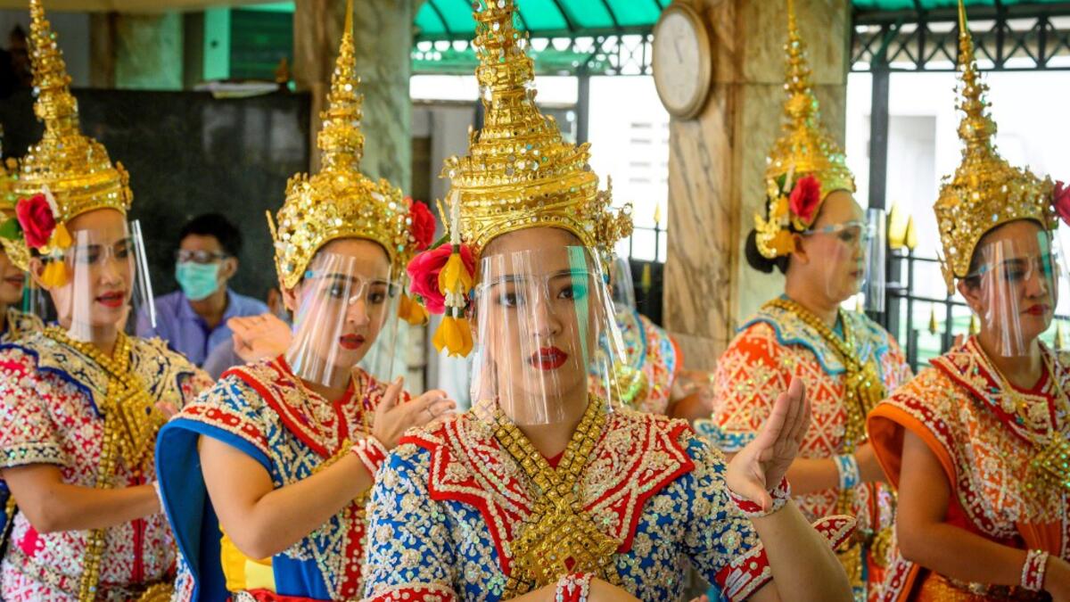Traditional Thai dancers wearing protective face shields perform at the Erawan Shrine, which was reopened after the Thai government relaxed measures to combat the spread of the COVID-19 novel coronavirus, in Bangkok on May 4, 2020. Thailand began easing restrictions related to the COVID-19 novel coronavirus on May 3 by allowing various businesses to reopen, but warned that the stricter measures would be re-imposed should cases increase again. Mladen ANTONOV / AFP