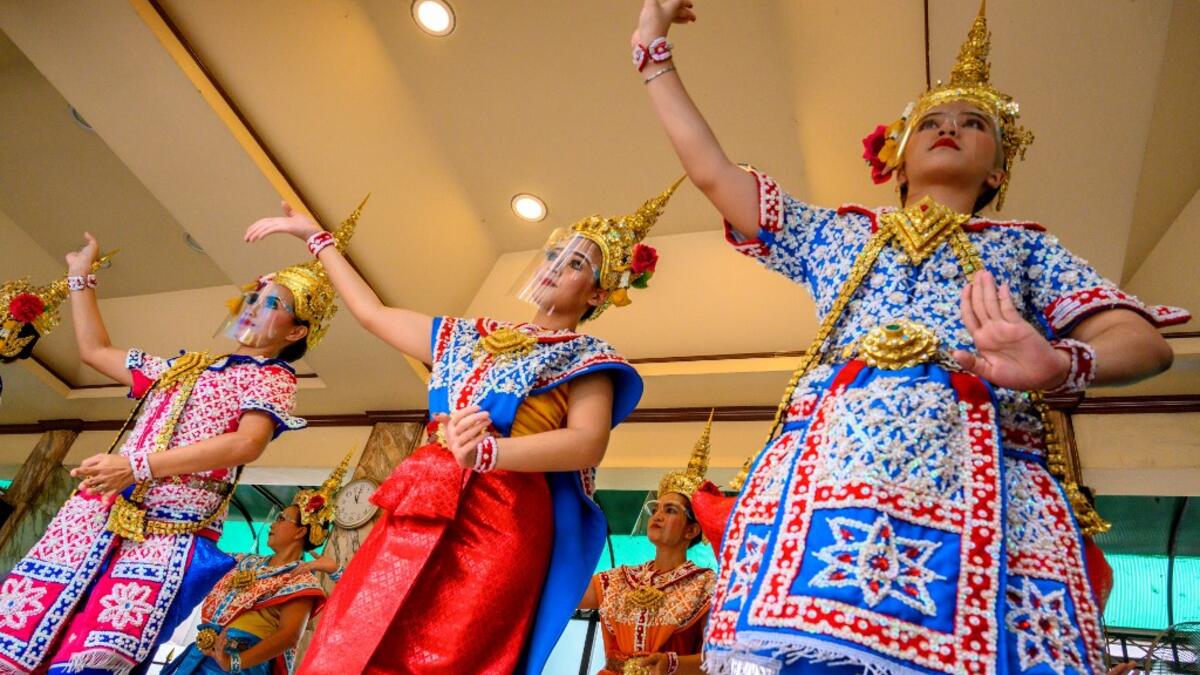 Traditional Thai dancers wearing protective face shields perform at the Erawan Shrine, which was reopened after the Thai government relaxed measures to combat the spread of the COVID-19 novel coronavirus, in Bangkok on May 4, 2020. Thailand began easing restrictions related to the COVID-19 novel coronavirus on May 3 by allowing various businesses to reopen, but warned that the stricter measures would be re-imposed should cases increase again. Mladen ANTONOV / AFP
