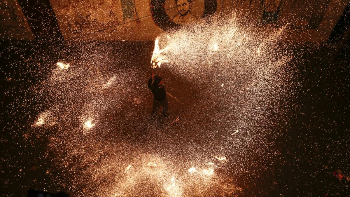 A Palestinian youth swings a homemade sparkler firework as people celebrate on a night of the Muslim holy month of Ramadan in Rafah refugee camp, in the southern Gaza Strip, on May 4, 2020. MAHMUD HAMS / AFP