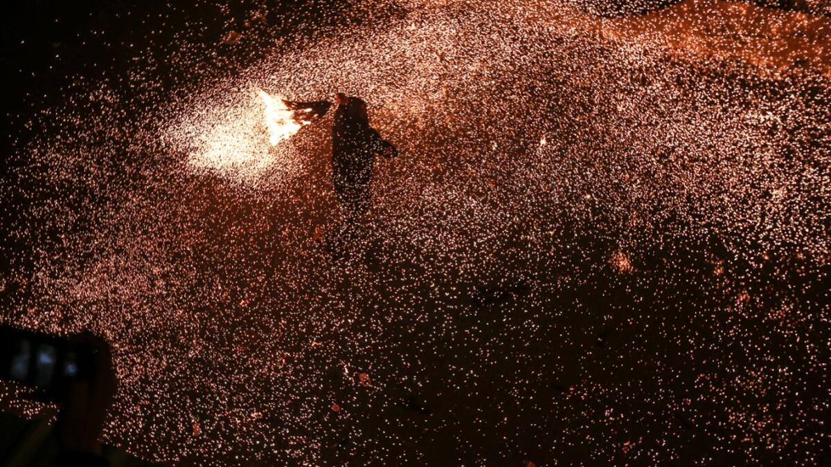 A Palestinian youth swings a homemade sparkler firework as people celebrate on a night of the Muslim holy month of Ramadan in Rafah refugee camp, in the southern Gaza Strip, on May 4, 2020. MAHMUD HAMS / AFP