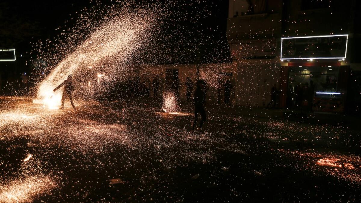 A Palestinian youth swings a homemade sparkler firework as people celebrate on a night of the Muslim holy month of Ramadan in Rafah refugee camp, in the southern Gaza Strip, on May 4, 2020. MAHMUD HAMS / AFP