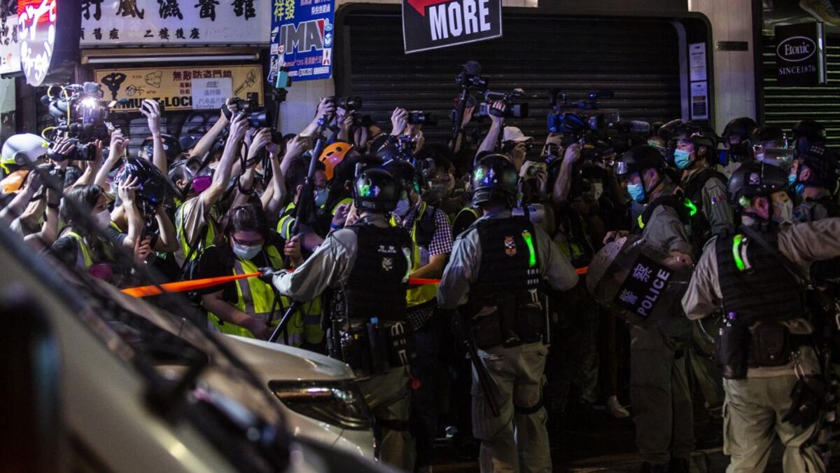 Riot police hold back members of the press during a police operation to arrest pro-democracy demonstrators during a protest calling for the city's independence in Mong Kok district of Hong Kong on May 10, 2020. ISAAC LAWRENCE / AFP