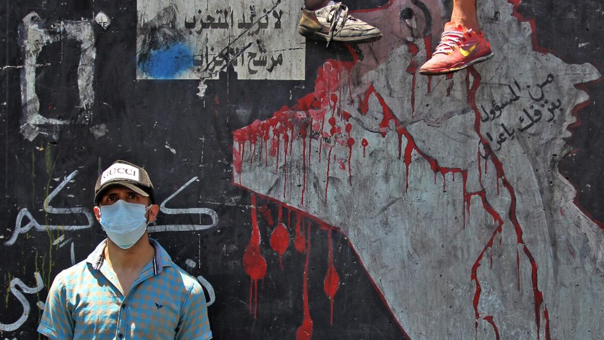 An Iraqi protester, wearing a protective mask, is pictured on the Al-Jumhuriyah bridge in the capital Baghdad on May 11, 2020, during an anti-government demonstration. AHMAD AL-RUBAYE / AFP