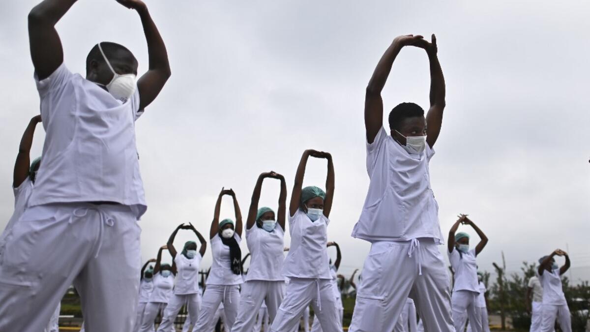 Nurses assigned to the Infectious Diseases Unit (IDU) at the Kenyatta University Hospital dance during a Zumba class held at the hospital compound in Nairobi, on May 17, 2020. Coinciding with the morning shift rotation the class, aimed to offer some respite to nurses charged with the management of patients infected with COVID-19 coronavirus, was organised by the Nursing Council of Kenya (NCK) and the Kenyatta Univesity Teaching, Refferal and Research Hospital in the Kenyan capital. TONY KARUMBA / AFP