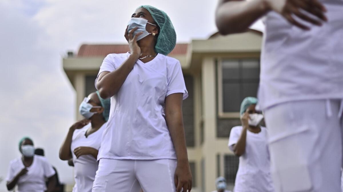 Nurses assigned to the Infectious Diseases Unit (IDU) at the Kenyatta University Hospital dance during a Zumba class held at the hospital compound in Nairobi, on May 17, 2020. Coinciding with the morning shift rotation the class, aimed to offer some respite to nurses charged with the management of patients infected with COVID-19 coronavirus, was organised by the Nursing Council of Kenya (NCK) and the Kenyatta Univesity Teaching, Refferal and Research Hospital in the Kenyan capital. TONY KARUMBA / AFP