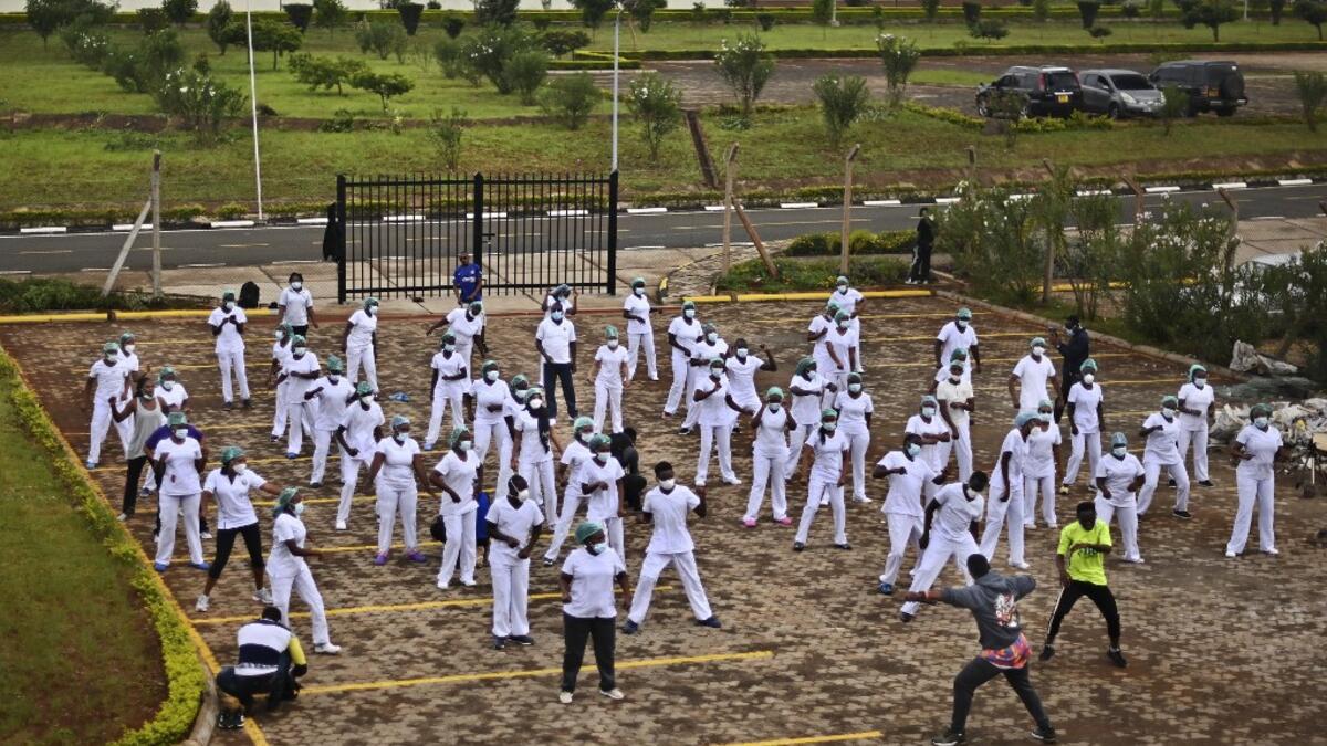 Nurses assigned to the Infectious Diseases Unit (IDU) at the Kenyatta University Hospital dance during a Zumba class held at the hospital compound in Nairobi, on May 17, 2020. Coinciding with the morning shift rotation the class, aimed to offer some respite to nurses charged with the management of patients infected with COVID-19 coronavirus, was organised by the Nursing Council of Kenya (NCK) and the Kenyatta Univesity Teaching, Refferal and Research Hospital in the Kenyan capital. TONY KARUMBA / AFP
