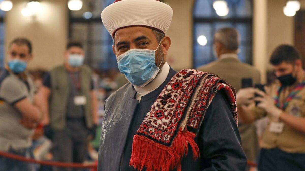 A Muslim cleric takes part in a morning prayer to celebrate the Eid al-Fitr holiday while wearing a protective mask due to the COVID-19 pandemic, at Mohammed al-Amin Mosque in the Lebanese capital Beirut's downtown district on May 24, 2020. ANWAR AMRO / AFP