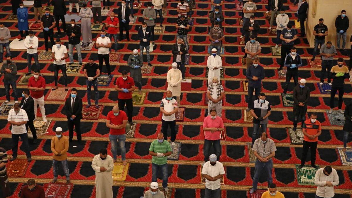 Muslim worshippers take part in a morning prayer to celebrate the Eid al-Fitr holiday while wearing protective masks and maintaining social distancing due to the COVID-19 pandemic, at Mohammed al-Amin Mosque in the Lebanese capital Beirut's downtown district on May 24, 2020. ANWAR AMRO / AFP