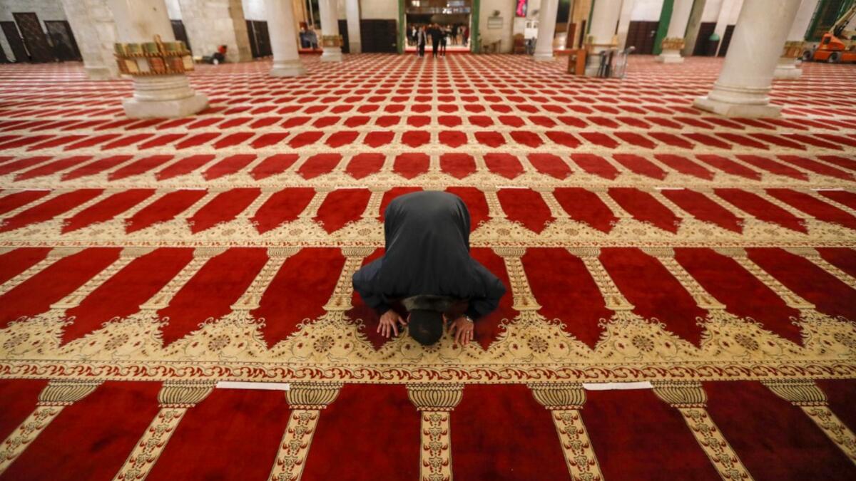 A Palestinian man performs the morning prayer inside Al-Aqsa mosque, before the start of the dawn prayer (salat al-fajr) in Jerusalem's Old City, on May 31, 2020, after a two-month closure due to the COVID-19 pandemic. AHMAD GHARABLI / AFP