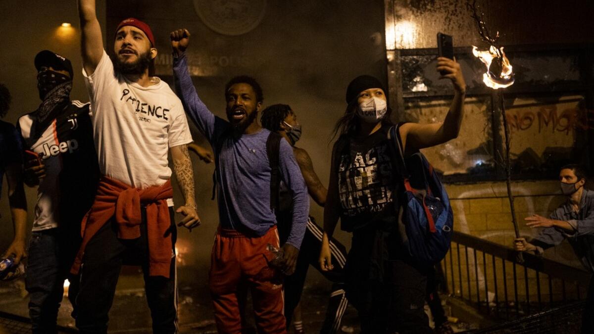 Protesters cheer as the Third Police Precinct burns behind them on May 28, 2020 in Minneapolis, Minnesota. As unrest continues after the death of George Floyd, police abandoned the precinct building, allowing protesters to set fire to it. Stephen Maturen/Getty Images/AFP